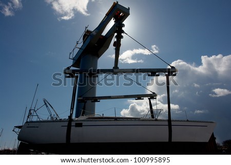 Sailboat lift up by a heavy industrial boat lifter for maintenance