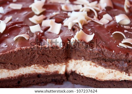 Delicious glazed chocolate cake decorated with white chocolate flakes