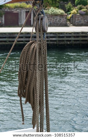 Nautical ropes and vintage wooden pulley on a sail boat sailing background image