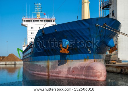 Medium size cargo container ship in the harbor port in frontal view