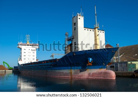 Medium size cargo container ship in the harbor port in side view