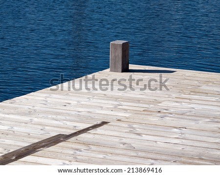 Small beautiful seaside wooden jetty dock pier deck by the ocean