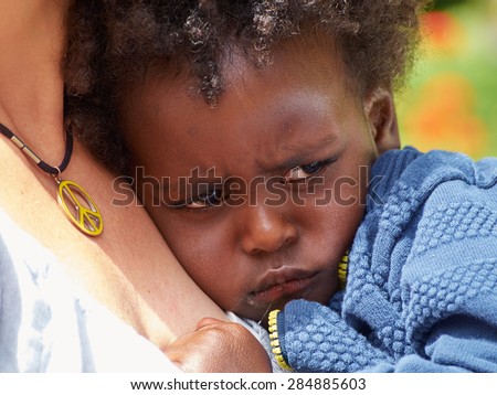 Adorable black sad baby crying with bad mood
