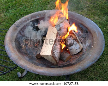 Beautiful copper fire pit bonfire with burning logs