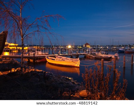 Boats and sail yachts in a busy marina at night