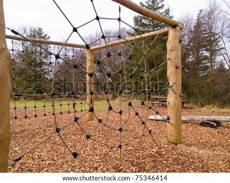 Jungle gym exercise equipment made of wood and ropes in a playground
