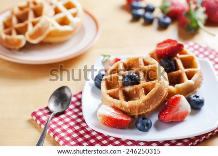 waffles with strawberry , blueberry and caramel sauce