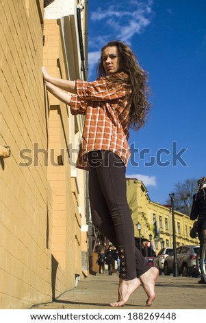 Portrait of a young  woman,   barefoot on a commercial street