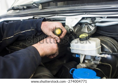 dirty car mechanic hands examining car automobile at repair service station
