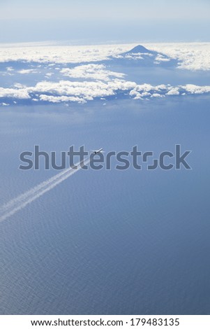 Airplane airline flying over ocean and volcanic island