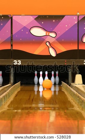 A bowling alley.  Gutter guards are up and ball is heading to the pins