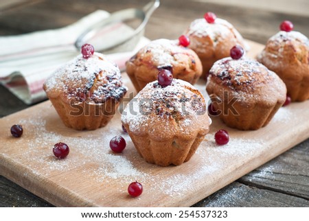 Muffins with black currant, sprinkled with powdered sugar and decorated with berries