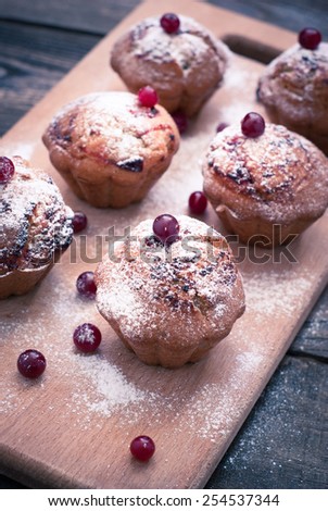 Muffins with black currant, sprinkled with powdered sugar and decorated with berries. image is tinted