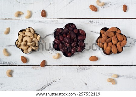 Almonds, cashews,  and briar in a cookie cutters. On a white wooden background