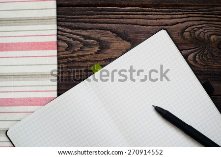 Wooden table with kitchen towel and notepad. Background  for writing prescriptions