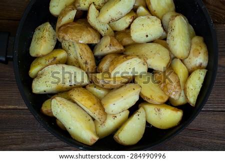 Frying pan with slices Baked potatoes with herbs and pepper