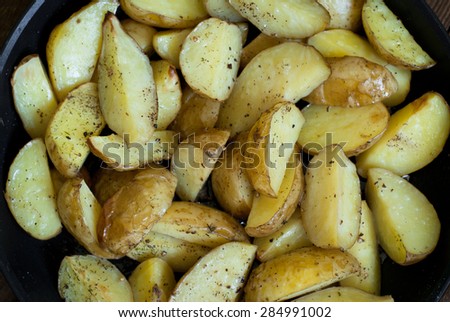 Frying pan with slices Baked potatoes with herbs and pepper