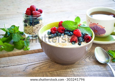 Healthy breakfast - oatmeal with berries and a cup of green tea