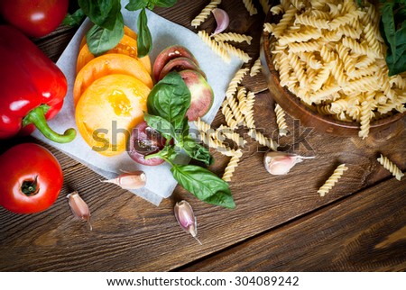 Ingredients for cooking pasta - fusilli, tomatoes, peppers, garlic and basil