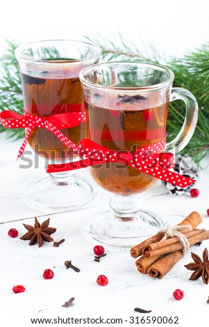 Hot christmas tea with spices - cinnamon, cloves and star anise on a light wooden background