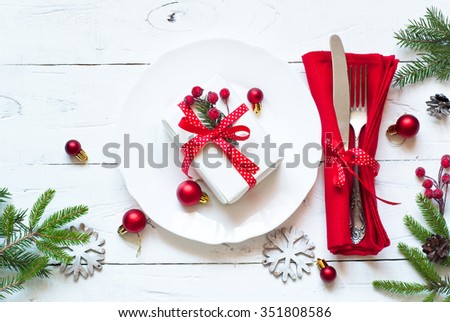 Christmas table setting with christmas decorations and gift at white table. Top view.