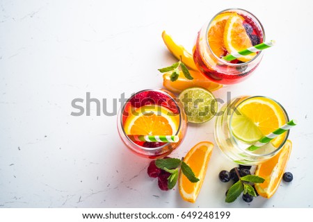 White, pink and red sangria with fruit and ice. Top view on white background. Summer alcohol drink.