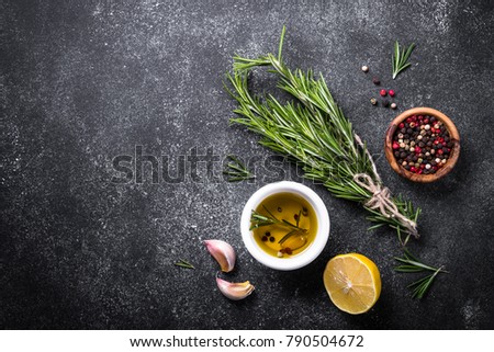 Selection of spices, herbs and olive oil on black stone table. Ingredients for cooking. Food background. Top view with copy space.