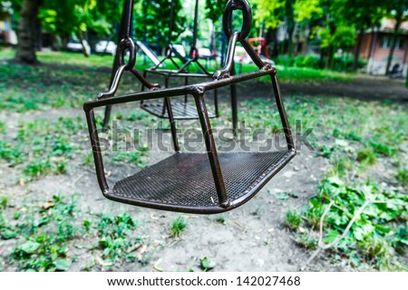 empty steel swing waiting for children to come on swinging/Empty swings on playground