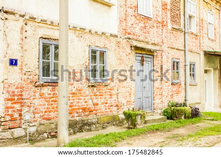 Old house brick wall with painted door and window