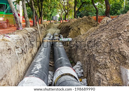 Work is in progress, burying pipeline in urban area.
