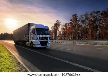 White truck driver on the road at sunset