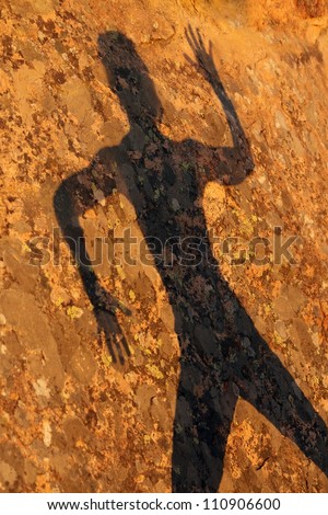 woman shadow on granite rock under warm sunset light