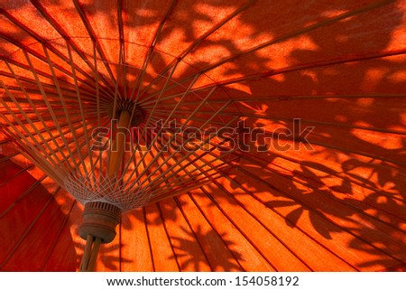 Oriental umbrellas and leaves shadow in Thailand