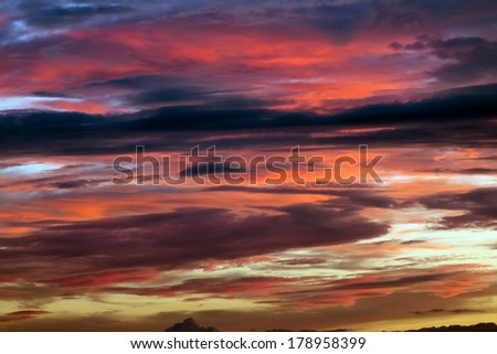 Scenic background of a beautiful vivid with shades of red and purple sunset on a cloudy overcast evening