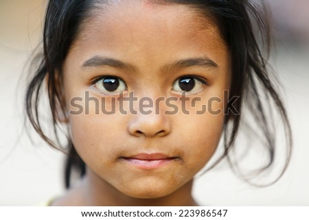 BHAKTAPUR, NEPAL, NOVEMBER 24, 2010: Close portrait of a Nepalese little girl posing in the main Bhaktapur square