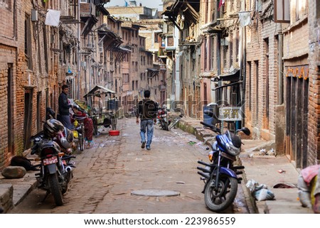 BHAKTAPUR, NEPAL, NOVEMBER 25, 2010: A man is walking in a narrow ancient street in Bhaktapur, Nepal