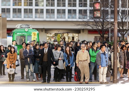 KYOTO, JAPAN, NOVEMBER 25, 2011: Pedestrians are waiting at the crosswalk in the Shibuya district in Tokyo, Japan