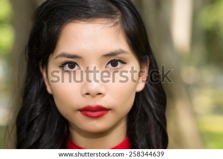 Close up Portrait of a Pretty Asian Young Woman Face with Make up Staring at the Camera.
