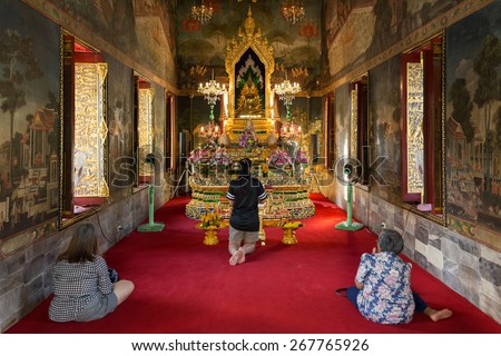 BANGKOK, THAILAND, JANUARY 14, 2015: Three Thai women are praying in the Wat pathum wanaram Bouddhist temple in Bangkok, Thailand.