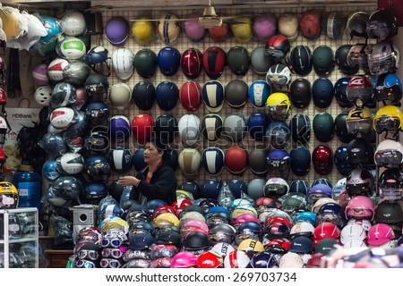 HANOI, VIETNAM, DECEMBER 15, 2014:A woman is specialized in the selling of motorbike helmets in her street shop in Hanoi, Vietnam