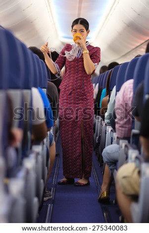 BANGKOK, THAILAND, DECEMBER 29, 2014 : An air hostess of the Thai Lion Air company is showing how to use oxygen mask before taking off from the Suvarnabhum airport in Bangkok, Thailand