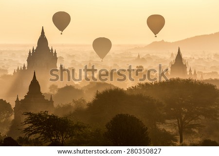 Air balloons flying over pagodas at misty dawn in the plain of Bagan, Myanmar (Burma)