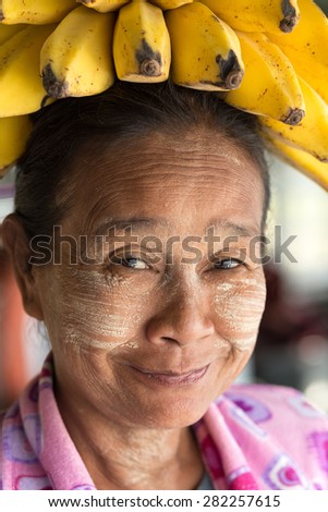 MANDALAY, MYANMAR, JANUARY 22, 2015: Portrait of a funny Burmese woman wearing a banana bunch on her head, in the slow boat from Mandalay to Bagan in Myanmar (Burma)