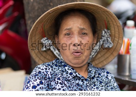 SAIGON, VIETNAM, FEBRUARY 26, 2015 : A funny senior woman is making a grimace in the streets of Saigon (Ho Chi Minh), Vietnam