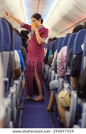BANGKOK, THAILAND, DECEMBER 29, 2014 : A air hostess of the Thai Lion Air company is showing how to use oxygen mask before taking off from the Suvarnabhum airport in Bangkok, Thailand