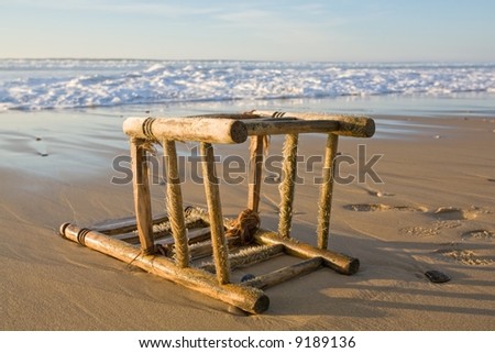 rotten chair damaged by ocean water on a wild beach