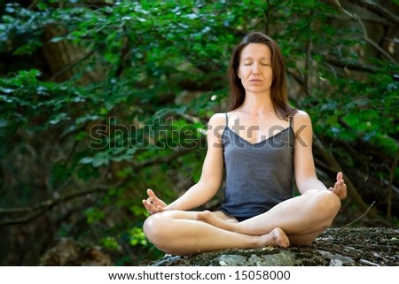 woman meditation on rock in wild forest