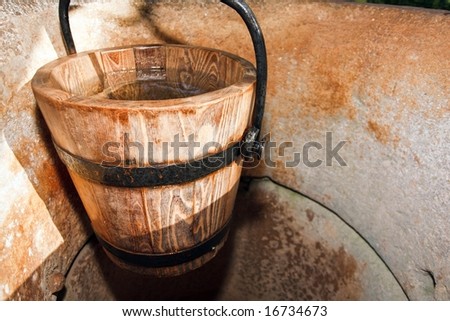 wooden bucket of water in ancient stone well