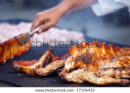barbecue of grilled chicken legs with chef\'s hands