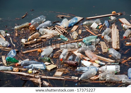garbage with plastic bottles wood and other pollution on lake water